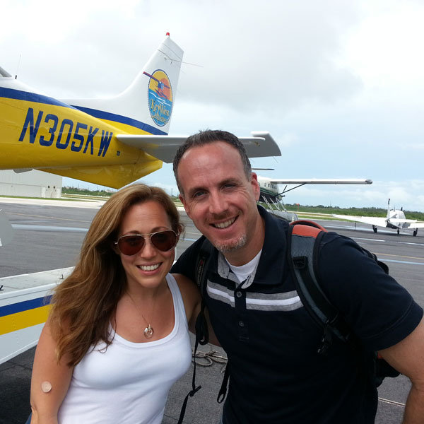 jen with her husband in front of the plane 
