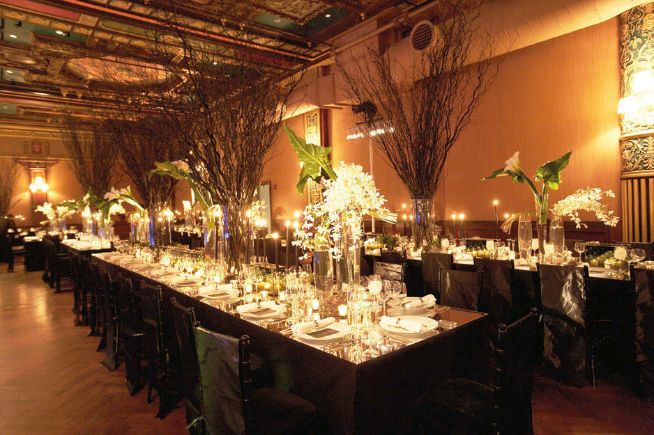 Here tall glass vases are filled with branches sprays of delicate flowers