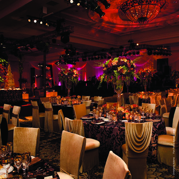 Rosecovered chairs enhance the glamour of this ballroom wedding reception 