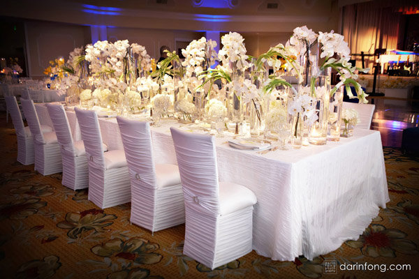 The high and low centerpieces add a pop of color reception chair cover