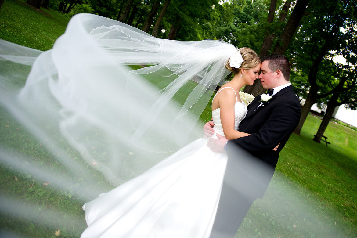 bride and groom wrapped in veil