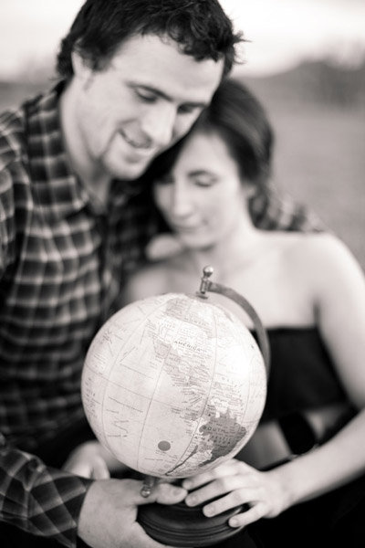 couple holding and looking at a globe