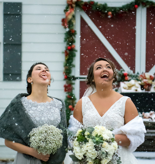 Bride and bridesmaid catching snowflakes