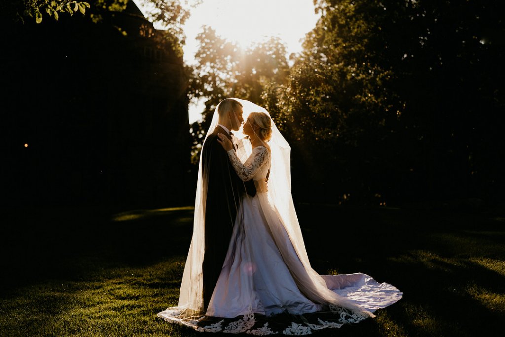 bride and groom under wedding veil