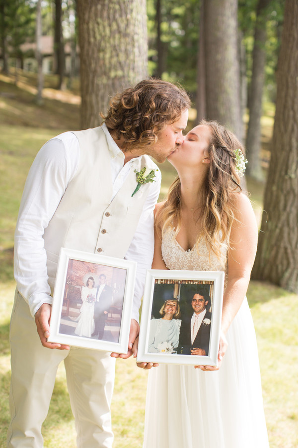 Bride and groom holding their parents wedding photos