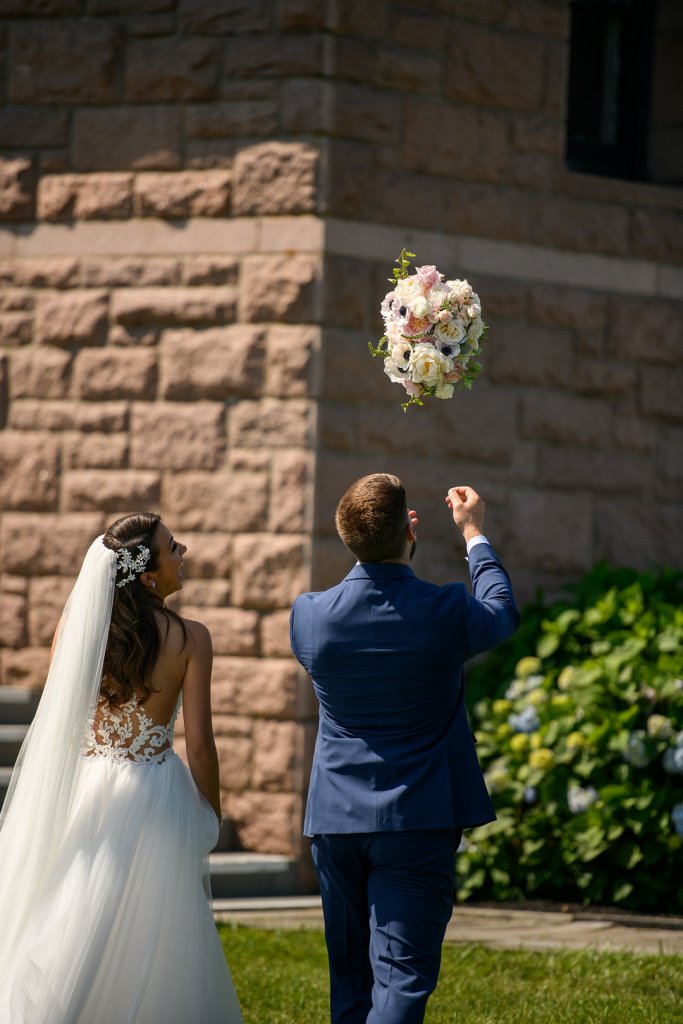 Groom tossing brides bouquet