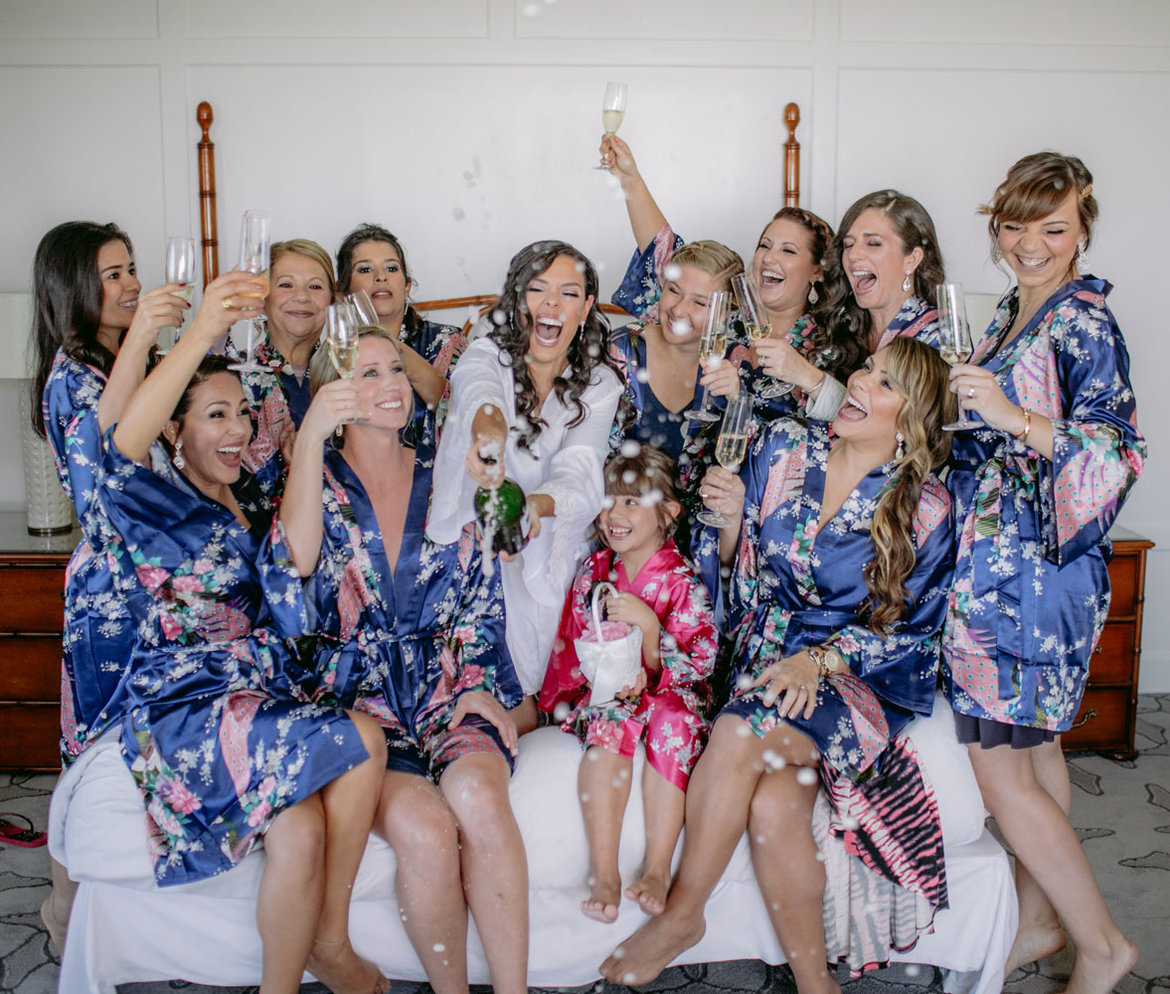 bride and bridesmaids popping champagne