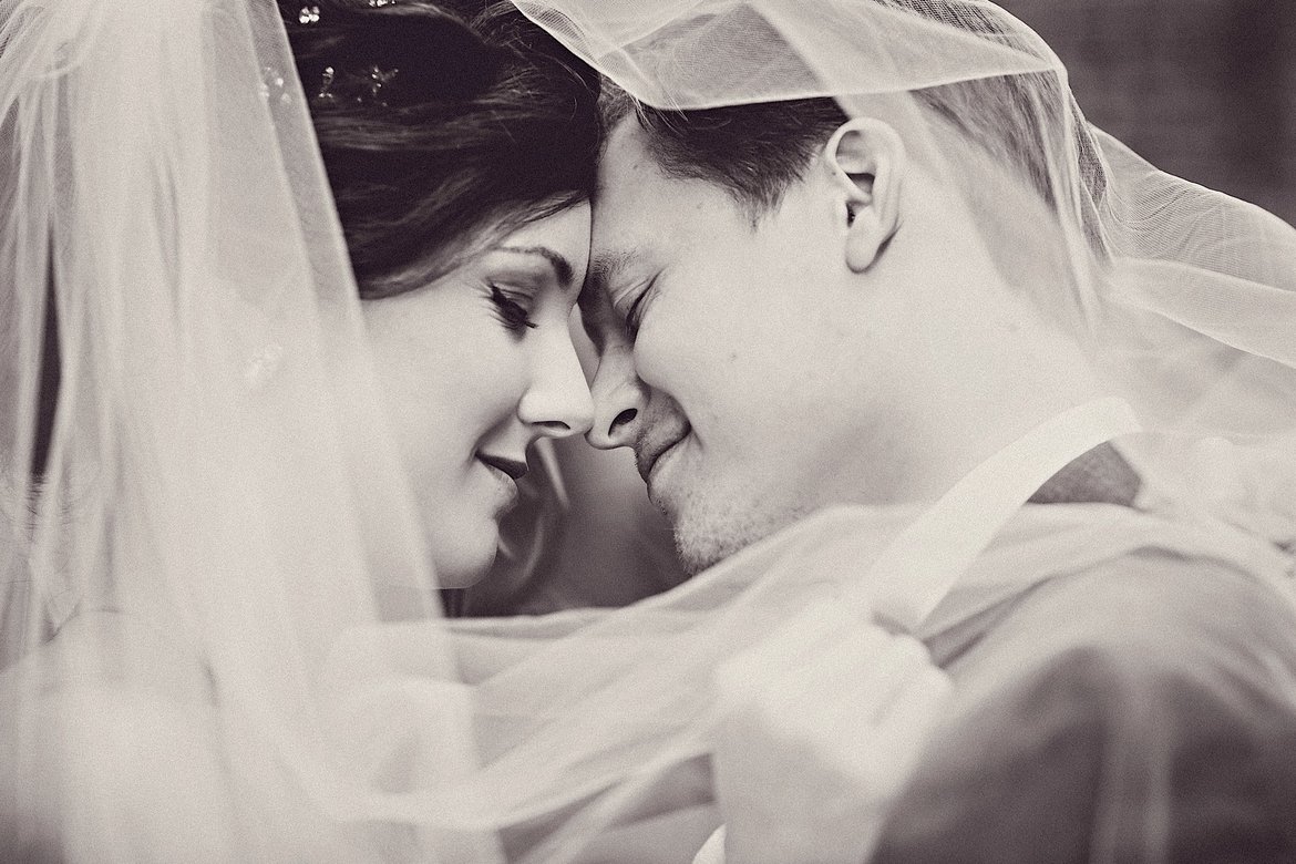 bride and groom under veil