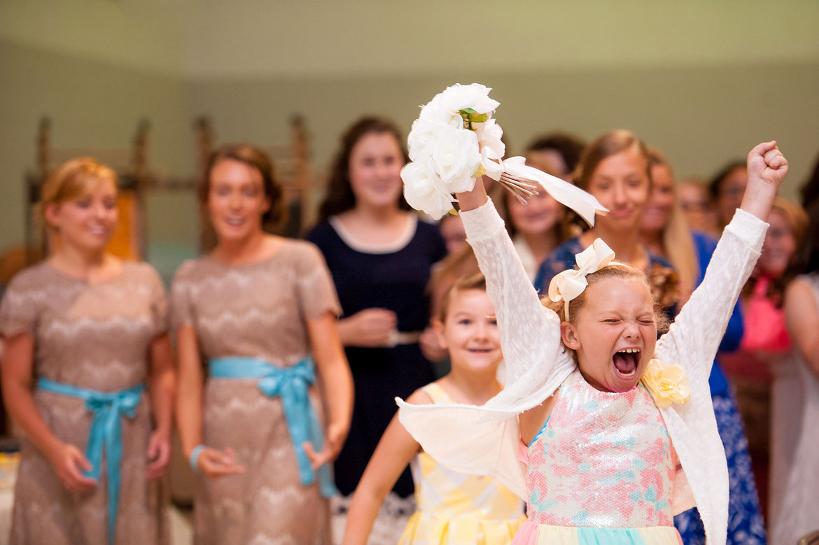 excited flower girl catching the bouquet