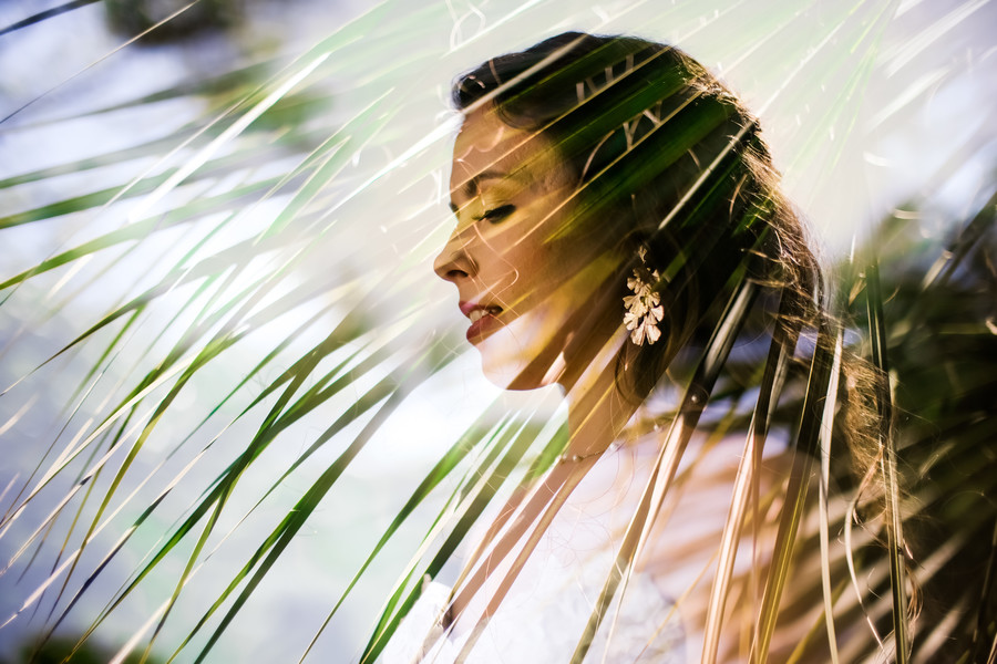 Bridal portrait through palm tree leaves