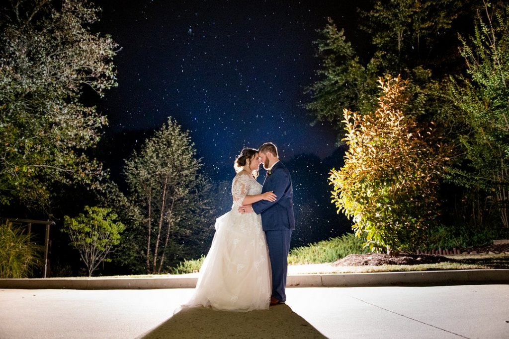 Bride and groom kiss beneath the stars