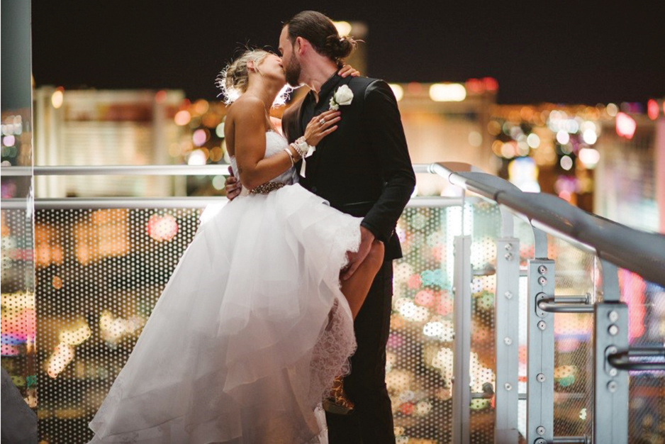 Bride and groom kissing on balcony