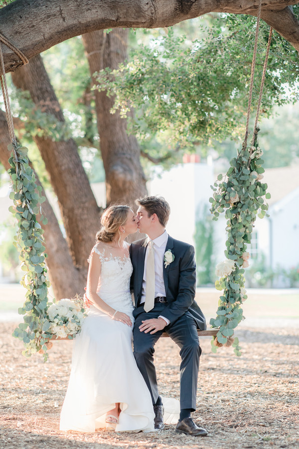 Bride and Groom Kissing on Swing