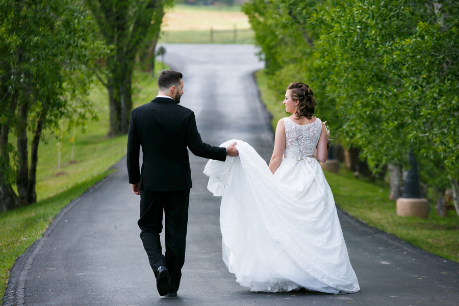 Groom Holding Brides Wedding Gown Train