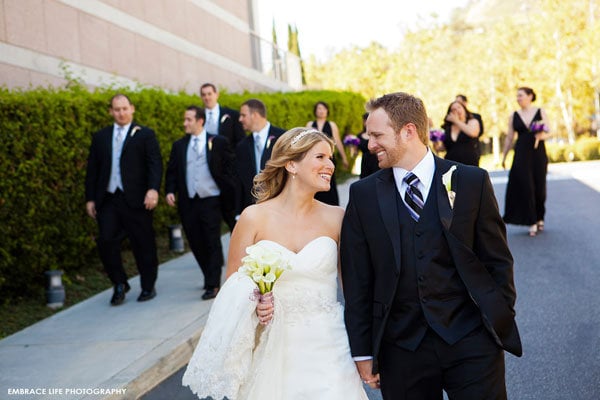 bride and groom with bridal party in the backround 