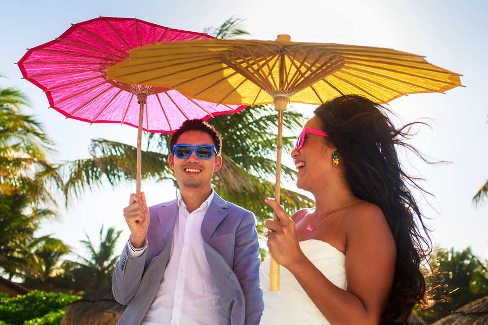 bride and groom with pink and yellow parasols