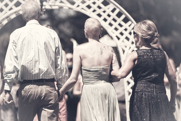 bride walking down the aisle with both parents