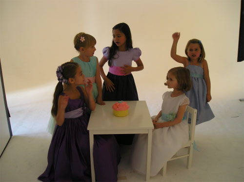 the flower girls patiently wait to eat the cupcake