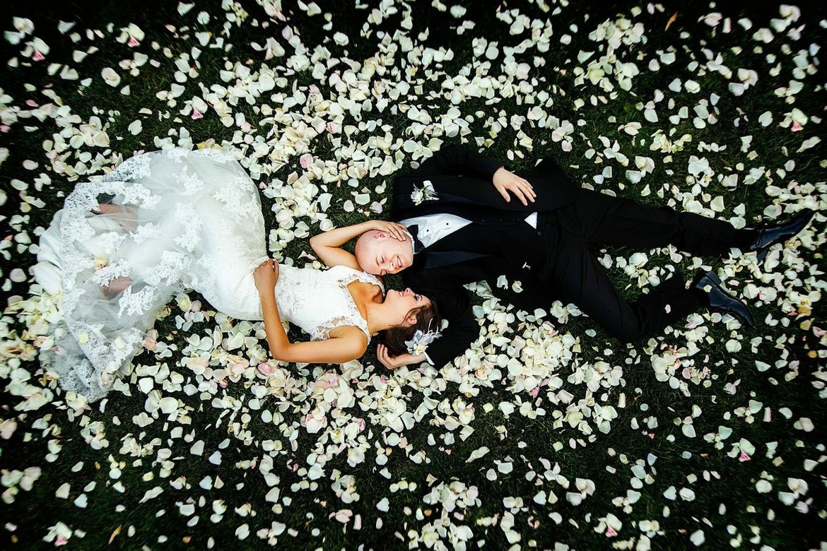 bride and groom surrounded by flower petals