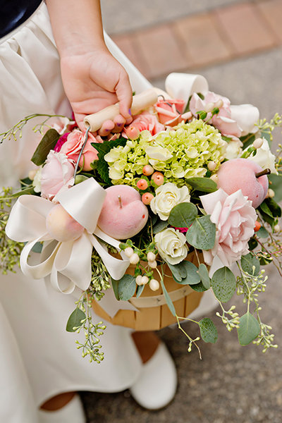 Flower girl basket with roses, hydrangeas, apples, seeded eucalyptus and bows