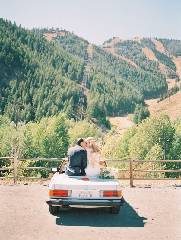 Couple sitting atop a car