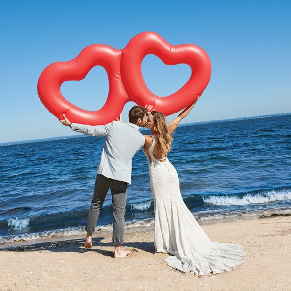 Allure Couture wedding gown on the beach with heart balloons