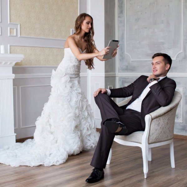 bride taking picture of groom