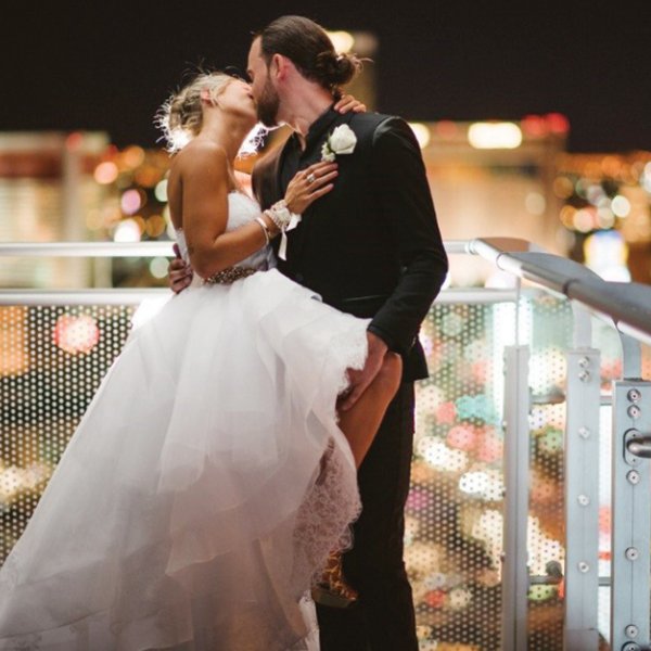 Bride and groom kissing on balcony
