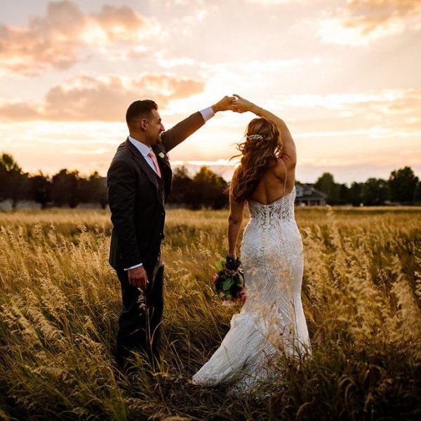 bride and groom dancing in a field