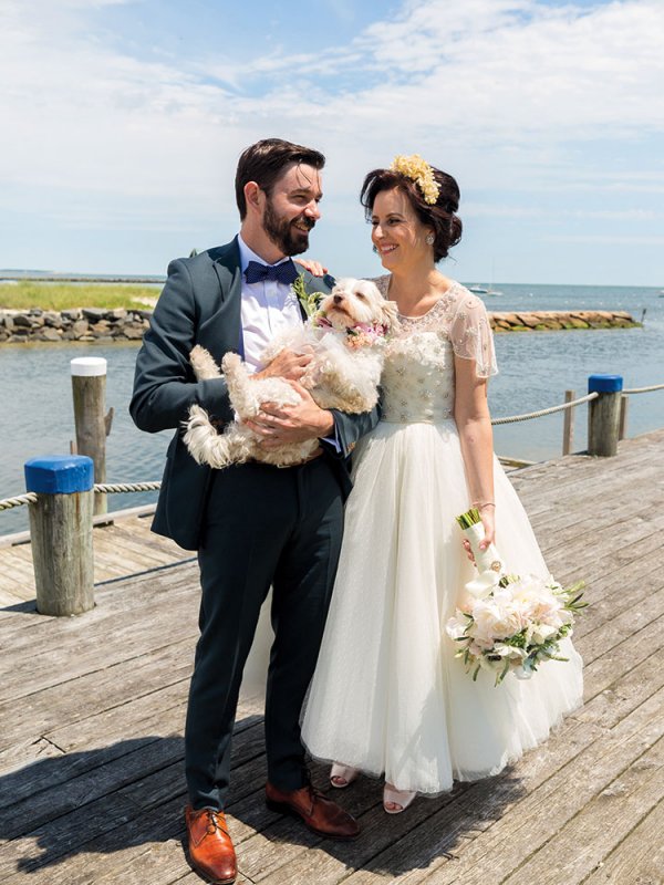 Bride and groom with dog on a pier Bride and groom with dog on a pier